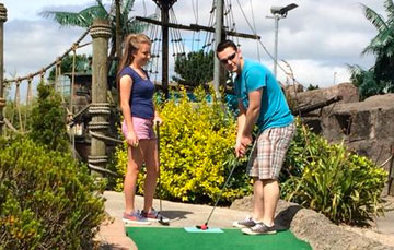 Man and woman playing mini golf